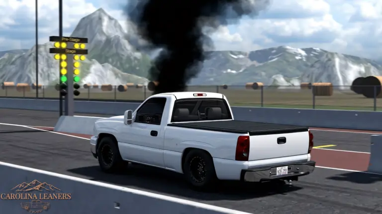 A white single-cab pickup launches off the line at the drag strip, black smoke rolling up behind it.