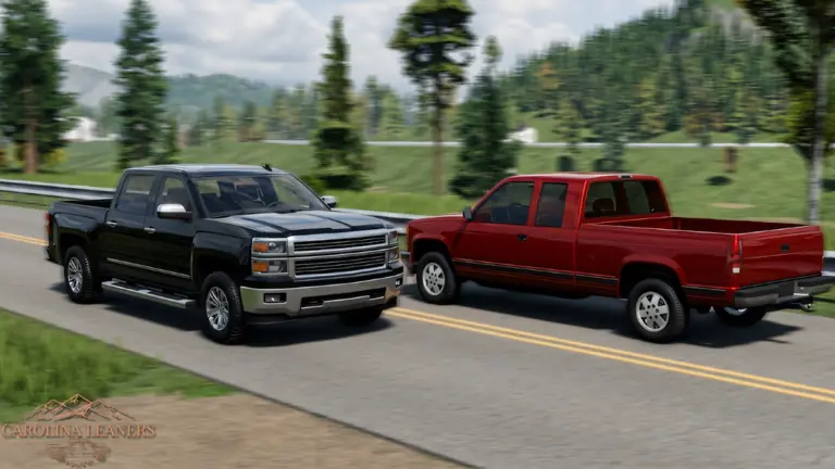 Two pickups cruising a two-lane highway through pine forest.