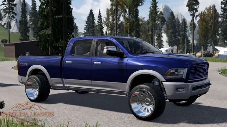A blue crew-cab pickup on polished wheels with snowy mountains behind it.